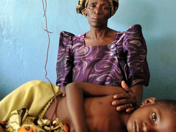 Một người mẹ Uganda đang chăm sóc đứa con bị sốt rét (Ảnh: Corbis) 