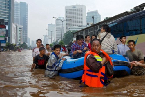 Nhà chức trách huy động xuồng cao su để cứu những người mắc kẹt vì nước lũ (Ảnh: AP)