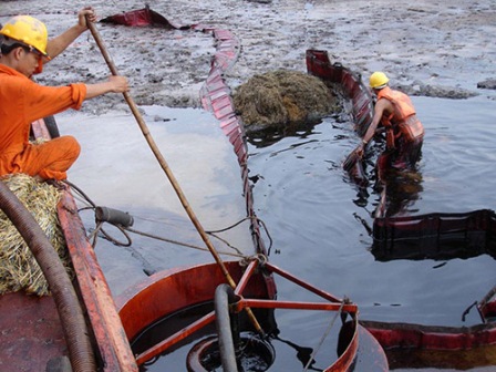 Nhân viên Công ty TNHH Cứu hộ - Cứu nạn Đại Minh trong một lần xử lý sự cố tràn dầu trên sông Sài Gòn (Ảnh: Tân Tiến/nld.com.vn)