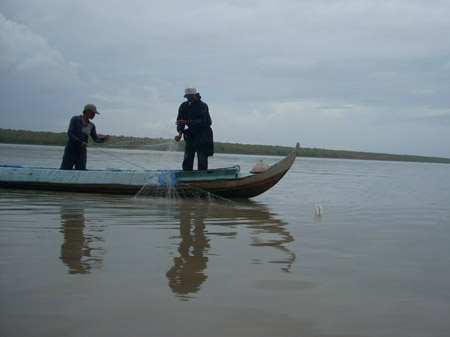 Hai “ngư tặc” đang thả lưới trên vùng cấm bãi bồi (Ảnh: Hải Đăng/ Dân việt)