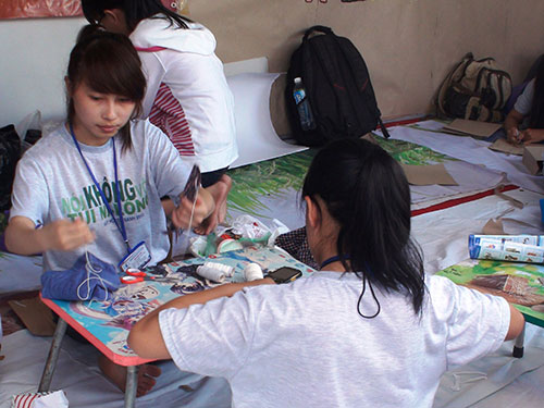 Các bạn trẻ tập làm túi thân thiện với môi trường tại Ngày hội Túi xanh vì môi trường xanh năm 2013 (Ảnh: www.nld.com.vn)