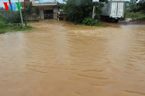 Nước từ quốc lộ 48 tràn vào nhà dân ở xã Nghĩa Thuận