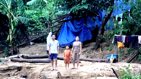 Gia đình ông bà Phạm Khắc Khánh cùng đứa cháu đang đứng trên nền đất không còn nhà...