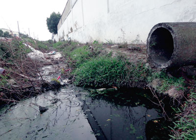 Đường ống xả thải của một nhà máy sản xuất phụ tùng cao su tại huyện Củ Chi, TPHCM, bên dưới là dòng nước đen ngòm chảy ra sông Sài Gòn-Đồng Nai (Ảnh: Ngọc Quý/Sài Gòn Giải Phóng)
