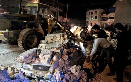 Nhân viên cứu hộ tìm kiếm nạn nhân ở thành phố Borazjan, Iran sau trận động đất (Ảnh: EPA/Chinhphu.vn)