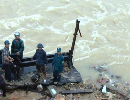 Nhà của một người dân huyện Phước Sơn, tỉnh Quảng Nam bị nước lũ làm sạt xuống sông (Ảnh: Trần Thường/nld.com.vn)