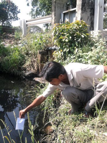 Anh Nguyễn Văn Nhung (ấp 1, xã Tân Nhựt, Bình Chánh) phản ánh tình trạng ô nhiễm nguồn nước tại cống số 8 (Ảnh: Trần Đăng/Dân Viêt)