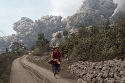 Một người dân chạy khi núi lửa Sinabung phun trào (Ảnh: Reuters)