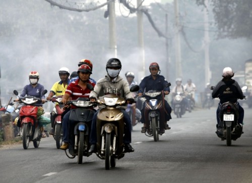 Người dân đi ngoài đường luôn phải bịt khẩu trang để tránh hít phải khói bụi ảnh hưởng đến sức khỏe (Ảnh: Hoàng Hải /TTXVN)