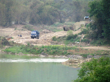 Đường ô tô được mở ngay trên lòng sông để phục vụ vận chuyển cát sỏi (Ảnh: Nông nghiệp Việt Nam)