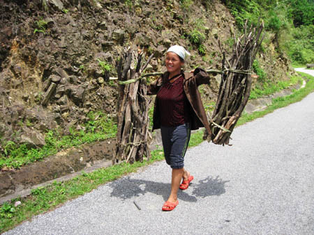 Mỗi ngày, những người đi rừng kiếm củi phải đi bộ hàng chục km, gánh trên vai nặng khoảng 50kg củi (Ảnh: Dân Việt)
