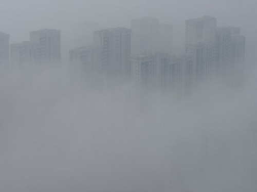 Những tòa nhà bị bao phủ trong khói và sương mù tại Thanh Đảo, tỉnh Sơn Đông, Trung Quốc (Ảnh: AP)