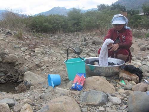 Người dân xã Hàm Cần, huyện Hàm Thuận Nam, tỉnh Bình Thuận đào hố dưới sông vét từng ca nước (Ảnh: Bạch Long/nld.com.vn)