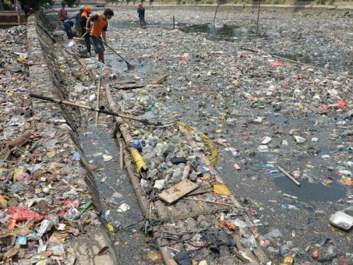 Công nhân dọn rác thải tại một con sông ở Jakarta ngày 8/10 (Ảnh: AFP/TTXVN)