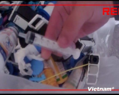 Những chiếc ống kim tiêm được lấy ra từ túi đựng rác thải y tế tại cơ sở thu mua phế liệu tại làng nghề Minh Khai. (Ảnh: Thùy Giang/VietnamPlus)