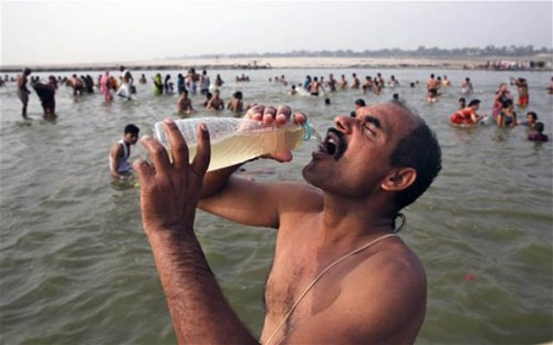 Người đàn ông ở Allahabad, Ấn Độ uống nước từ dòng sông Hằng linh thiêng (Ảnh: Telegraph)
