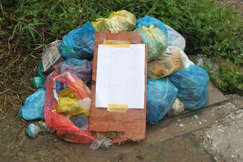 Một hộ dân bị đường dây thu gom rác làm khó nên phải viết bảng “van xin” (Ảnh: nld.com.vn)