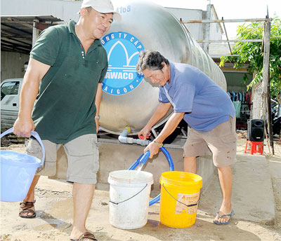 Người dân phường Thạnh Lộc, quận 12 sử dụng nước sạch từ bồn cấp nước công cộng (Ảnh: Cao Thăng/Sài Gòn Giải Phóng)