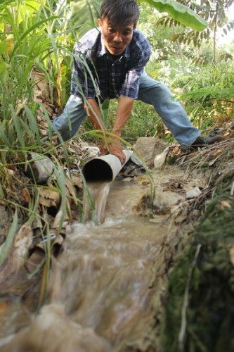 Ống nước thải của Công ty Quang Vinh xả ra môi trường chưa qua xử lý (Ảnh: nld.com.vn)