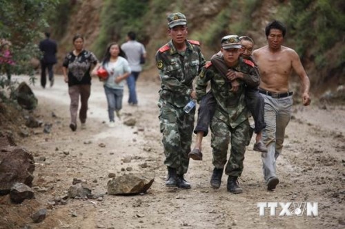 Lực lượng cứu hộ hỗ trợ người dân bị thương trong trận động đất tại huyện Lỗ Điện ngày 3/8 (Ảnh: THX/TTXVN)