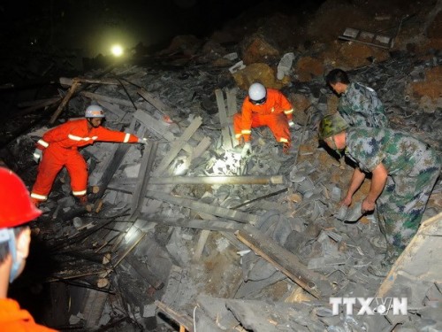 Nhân viên cứu hộ tìm cứu người mất tích tại hiện trường vụ lở đất ngày 28/8 (Ảnh: THX/TTXVN)