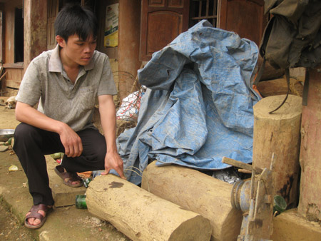 Phó ban Tự quản lâm nghiệp xóm Khú, Bùi Văn Tường với những khối gỗ vừa thu được của lâm tặc (Ảnh: Đại Đoàn Kết)