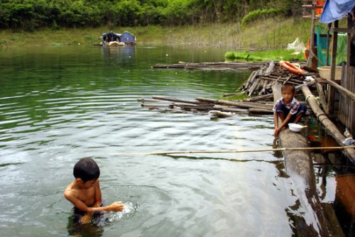 Những đứa trẻ ở làng chài đều bỏ học ở nhà phụ giúp cha mẹ mưu sinh bằng nghề đánh bắt cá (Ảnh: Nhân Dân)