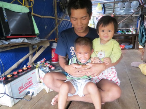 Nguyễn Văn Toàn, 26 tuổi (con đầu anh Diên) và hai đứa con nheo nhóc trên chiếc bè tạm của gia đình trên lòng hồ thủy điện Đồng Nai 3 (Ảnh: Nhân Dân)