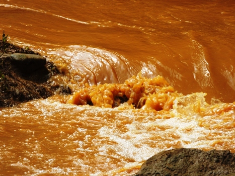 Nước suối đỏ ngầu chảy ầm ầm (Ảnh: VietNamNet)