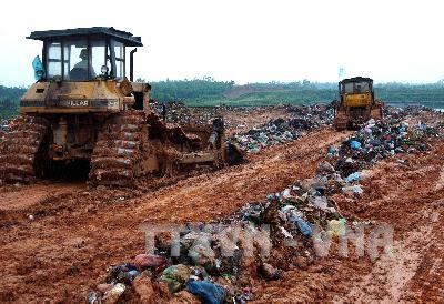 Chôn lấp rác thải ở bãi rác Nam Sơn (Ảnh minh họa: Bùi Tường - TTXVN)