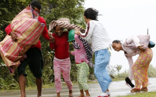 Gia đình Philippines nhanh chóng mang theo đồ đạc tránh bão (Ảnh: EPA)