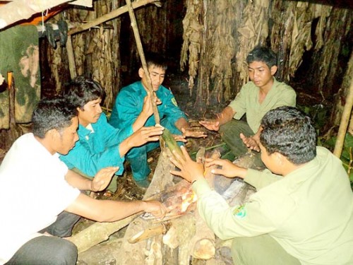 Sau khi tuần tra, các thành viên của tổ liên ngành ngồi sưởi ấm bên bếp lửa giữa rừng. (Ảnh: Sài Gòn Giải Phóng)
