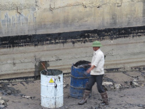 Các thùng phuy chứa dầu được bưng xuống tận lòng sông để thu gom dầu tràn