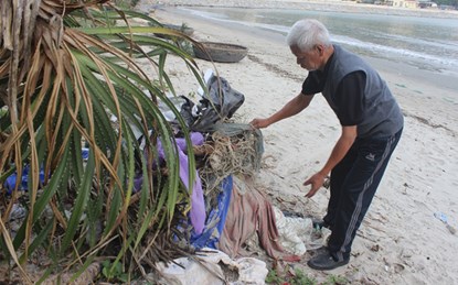Quanh năm, ông Mạo cần mẫn với việc nhặt rác tại bãi biển Nam Ô. (Ảnh: Dũ Tuấn)