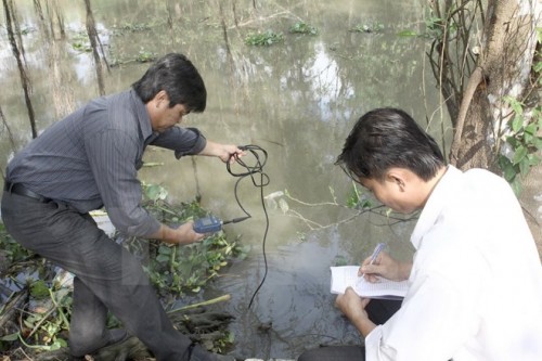 Đo nồng độ mặn trên sông Cái Lớn. (Ảnh: Duy Khương/TTXVN)