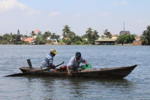 Các chuyên gia lấy mẫu nước trên sông Đồng Nai để phân tích, xét nghiệm. (Ảnh: Xuân Hoàng)