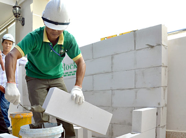 Công nhân Công ty cổ phần Vương Hải (huyện Vĩnh Cửu) xây dựng tường bằng gạch bê tông nhẹ. (Ảnh: Diễn đàn Doanh nghiệp) 