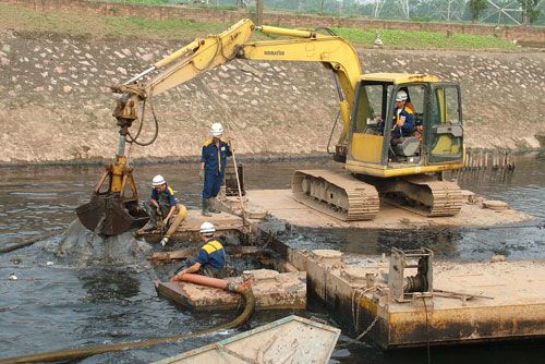 Công nhân Công ty Thoát nước nạo vét thu gom rác thải trên sông Kim Ngưu. (Ảnh: Khánh Nguyên)