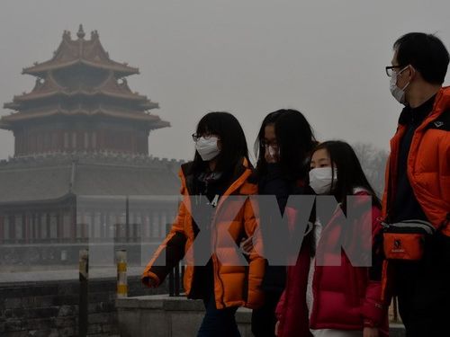 Khách du lịch đeo khẩu trang tránh bụi tại Bắc Kinh. (Nguồn: THX/TTXVN)