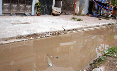 Những "ao" nước bẩn khổng lồ giữa đường vào khu tổ dân phố 26. (Ảnh: Xuân Tùng)