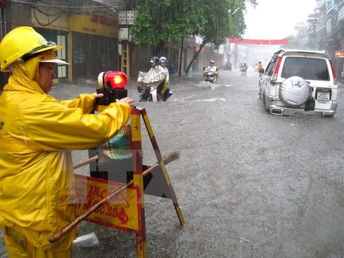 Công ty thoát nước Hà Nội cắm biển cảnh báo điểm nguy hiểm trên tuyến đường bị ngập lụt. (Ảnh: Nhật Anh/TTXVN)