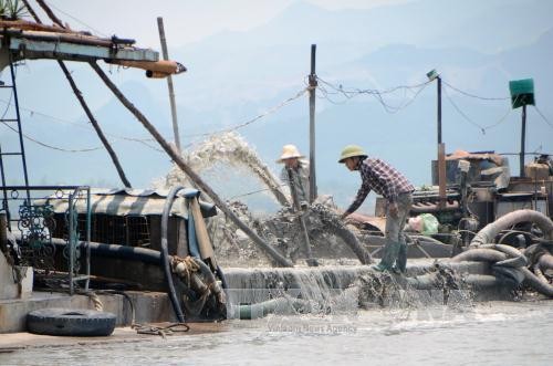 Một tàu đang thực hiện công việc hút cát trái phép (Ảnh: Nguyễn Hoàng/ TTXVN)