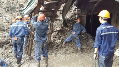 Công nhân Công ty Than Hòn Gai đang phá dỡ cửa lò sau khi bị mưa lũ đẩy một lượng đất đá khổng lồ bít cửa lò (Ảnh: Lao Động)