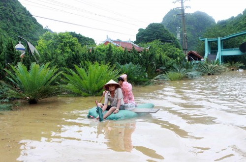 Nhiều phương tiện tự chế được sử dụng để đi qua vùng nước ngập lụt (ảnh chụp lúc 16 giờ, dốc đèo Bụt, phường Hà Phong ). (Ảnh: Minh Quyết/TTXVN)