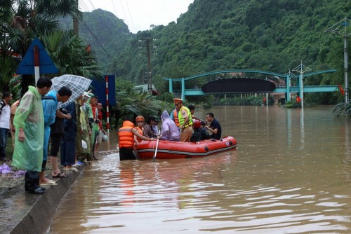 Các lực lượng cứu hộ giúp người dân di chuyển qua vùng ngập sâu. (Ảnh: Minh Quyết/TTXVN)