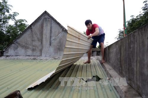 Người dân phải lợp tạm mái nhà sau khi bị đá từ mỏ đá rơi làm thủng mái (Ảnh: Hưng Thịnh/Báo Tin Tức)
