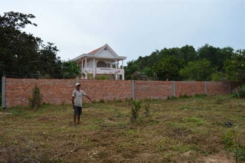 Một ngôi nhà người dân cất tạm bợ trên đất bao chiếm trái phép, vườn cây mới được trồng.