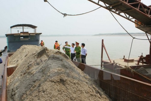 Đội Cảnh sát Môi trường Công an huyện Phúc Thọ xử lý doanh nghiệp khai thác cát trái phép (Ảnh: Doãn Tuấn/TTXVN)