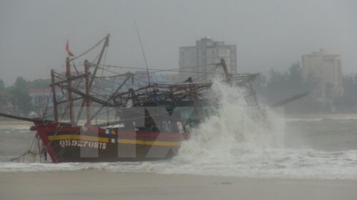 Một tàu cá bị mắc cạn, có nguy cơ bị sóng đánh chìm tại cửa biển Nhật Lệ, thành phố Đồng Hới, tỉnh Quảng Bình (Ảnh: TTXVN)