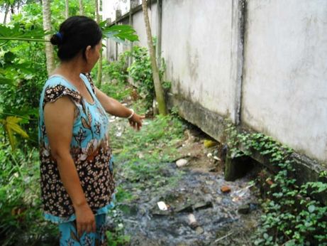 Bà Dung chỉ tay về nguồn nước đen ngòm từ bệnh viện đang vô tư xả thẳng ra môi trường (Ảnh: Hoàng Hạnh)